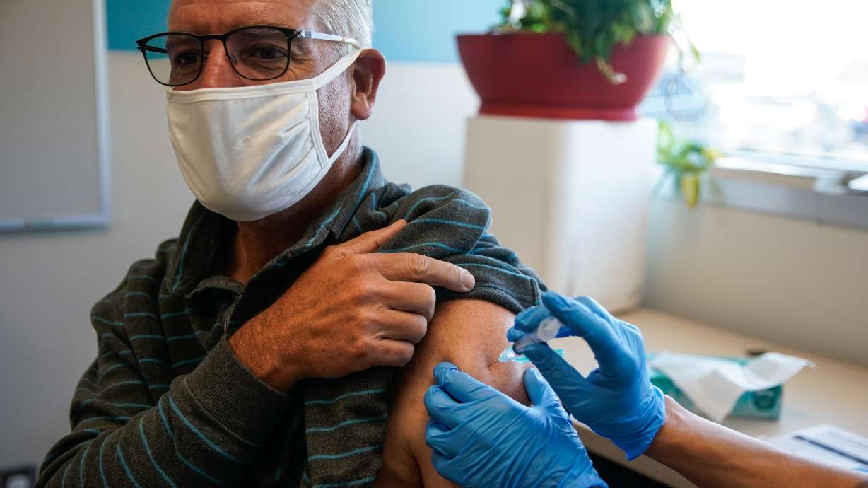 Salt Lake City resident Kim Irwin Pack receives an influenza vaccine on Sept. 30. As the U.S. Department of Health and Human Services announced Tuesday COVID-19 vaccines may have helped prevent 200 deaths among older adults in Utah during the first five months of this year, doctors at University of Utah Health urged those over age 65 to get a booster shot.