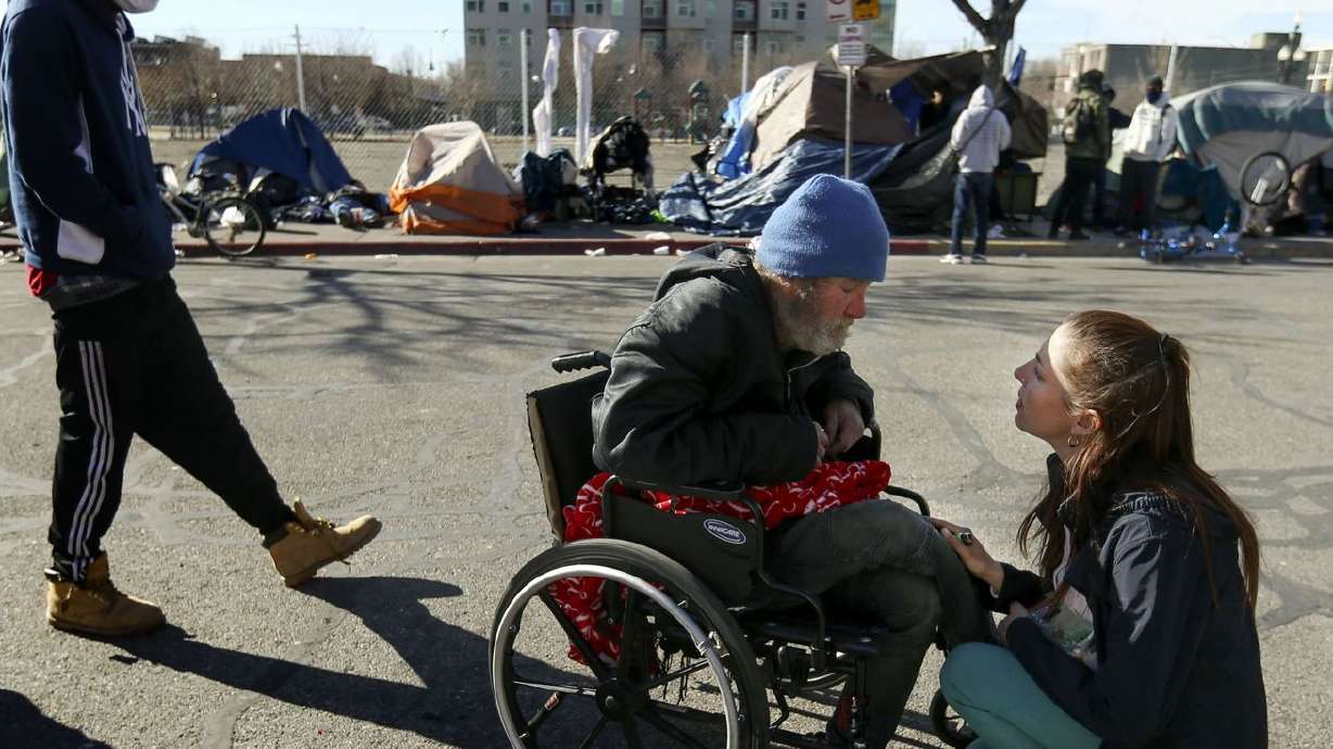 Kseniya Kniazeva, executive director of Nomad Alliance, speaks to Jason Gove about obtaining a new wheelchair for him on
Rio Grande Street in Salt Lake City on Sunday, Feb. 7, 2021. Salt Lake City Mayor Erin Mendenhall wants to ban the creation of any new, permanent homeless shelters in her city for the next six months.