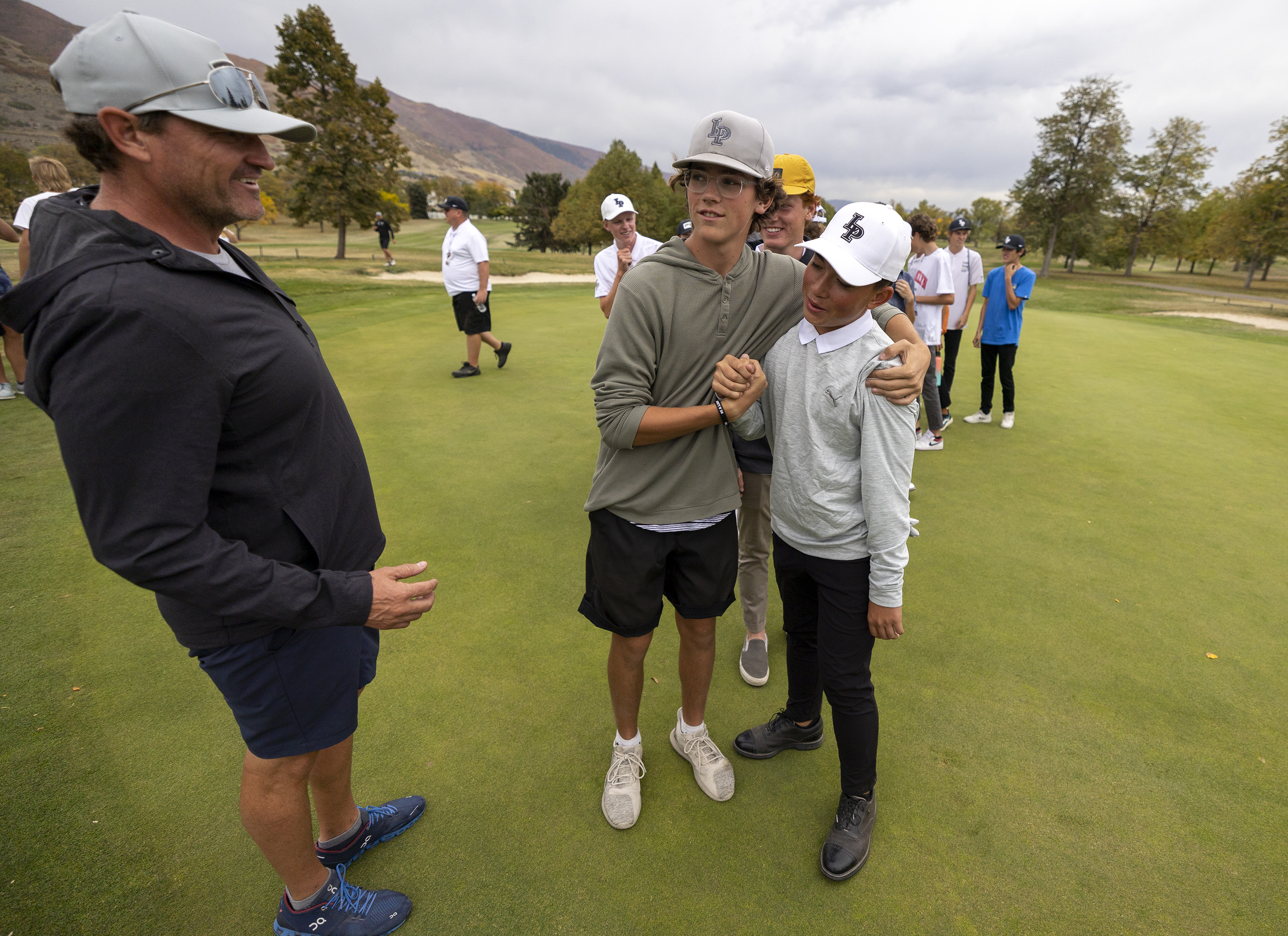 Lone Peakās Kihei Akina, right, celebrates the win in theĀ 6A boys state tournament with teammates at Davis Park Golf CourseĀ in Kaysville on Tuesday, Oct. 5, 2021.