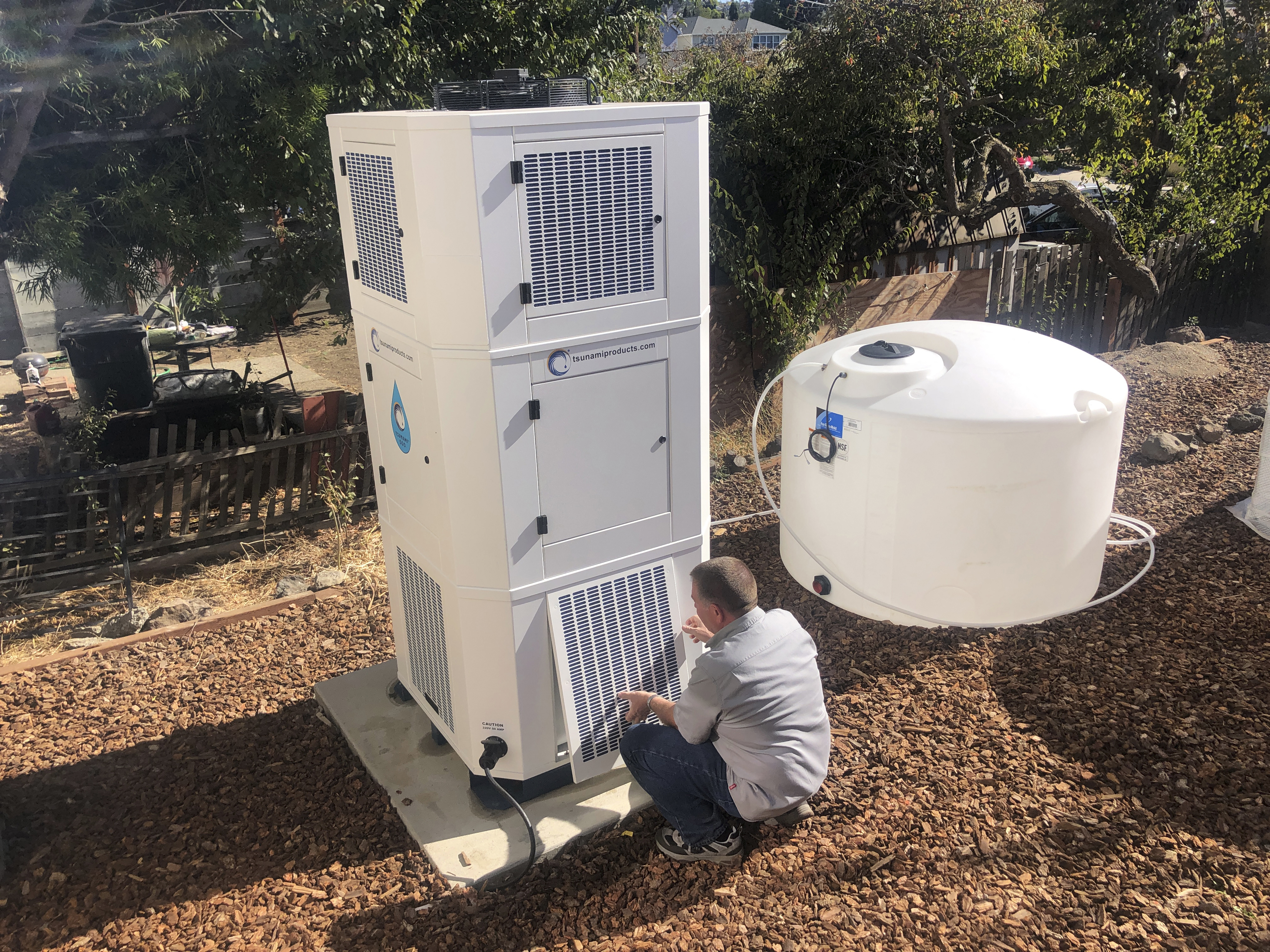 Ted Bowman, design engineer with Tsunami Products, installs a unit in homeowner Don Johnson's backyard in Benicia, Calif., Sept. 28. The recent invention can make water out of the air. 