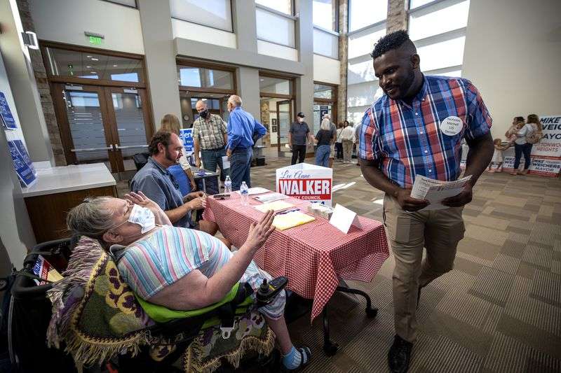 Nick Mitchell, a U.S. Senate candidate, right, moves
around a table to talk with Cottonwood Heights City Council
candidate Lee Anne Walker during a meet-the-candidates meeting in
Cottonwood Heights on Tuesday, Sept. 14.