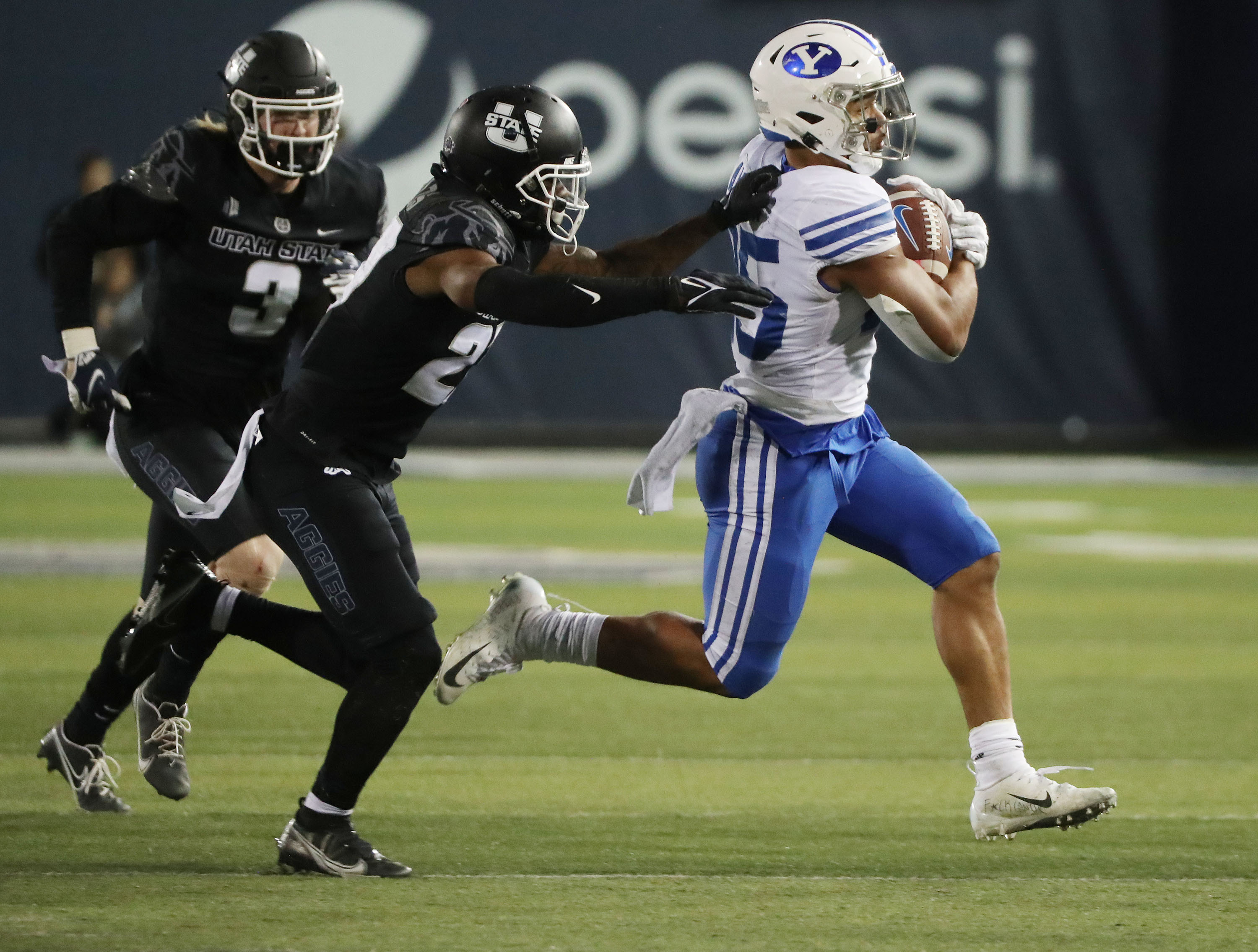Brigham Young Cougars Tyler Allgeier (25) runs against the Utah State Aggies during a game in Logan on Friday, Oct. 1, 2021.