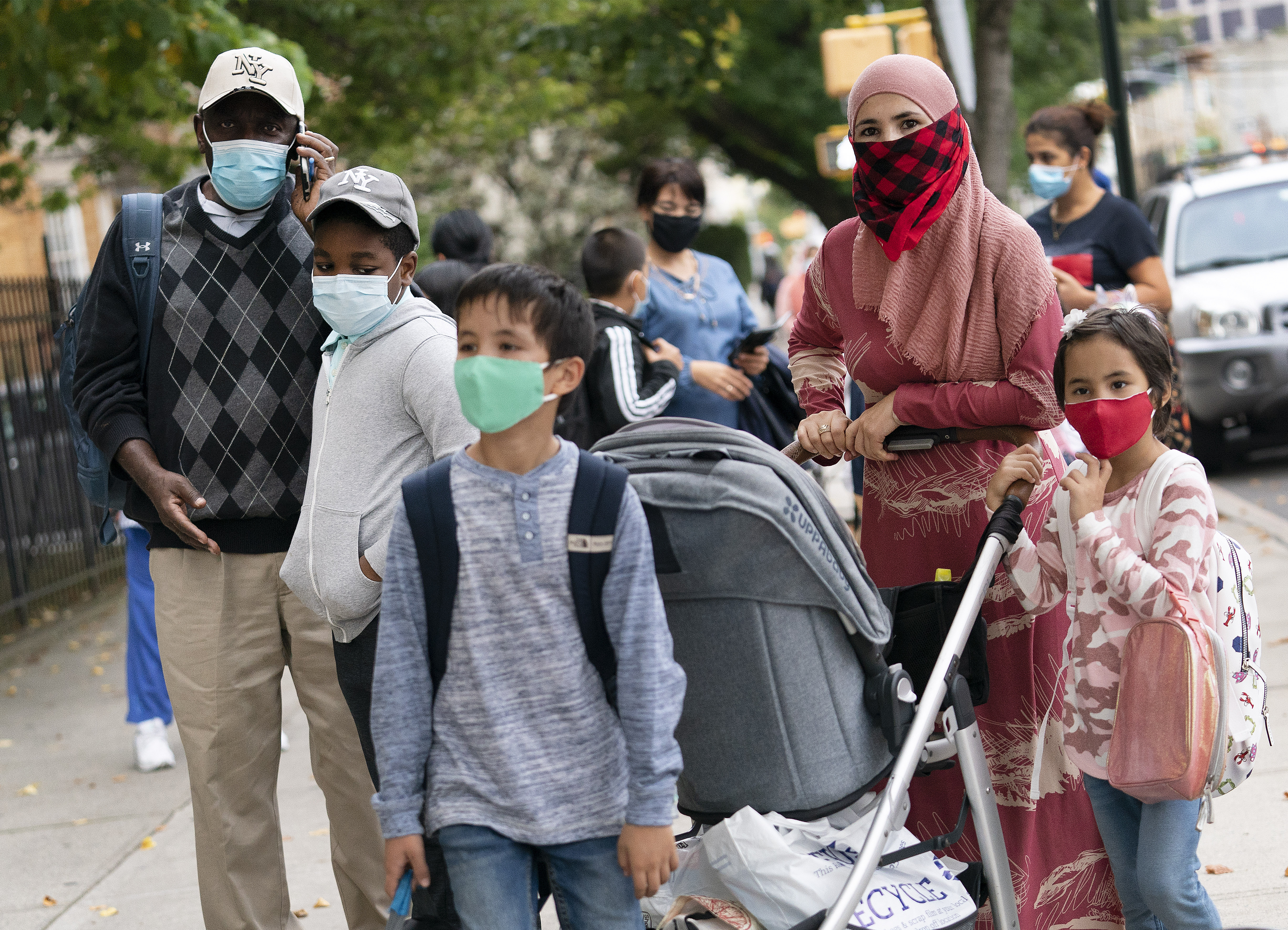 Parents accompany their children outside PS 179 elementary school in the Kensington neighborhood in the Brooklyn borough of New York, in this Tuesday, Sept. 29, 2020 photo. Pfizer asked the U.S. government Thursday to allow use of its COVID-19 vaccine in children ages 5 to 11 — and if regulators agree, shots could begin within a matter of weeks.