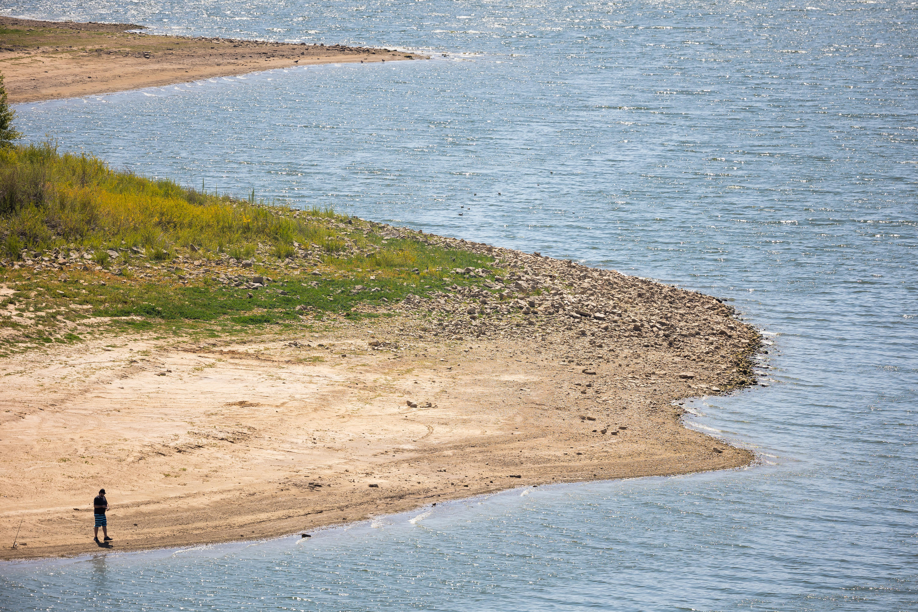 A man stands along dry shoreline at Scofield Reservoir on Aug. 27. The reservoir, now at 22% full, is an example of the 34 "conservation pools" that the Utah Division of Wildlife Resources has.
