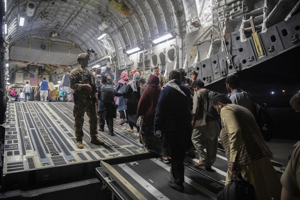 Afghan passengers board a U.S. Air Force C-17 Globemaster III during the Afghanistan evacuation at Hamid Karzai International Airport in Kabul, Afghanistan Aug. 22. An Afghan man who worked for the U.S. government in Afghanistan says the Biden administration has ignored his pleas for help to evacuate his two young sons from Afghanistan after their mother died of a heart attack while being threatened by the Taliban. 