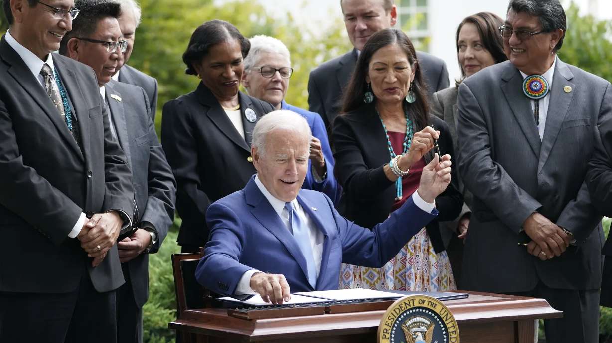 President Joe Biden hands a pen to Interior Secretary Deb Haaland as he signs a proclamation on the North Lawn at the White House in Washington on Friday, during an event announcing that his administration is that have been at the center of a long-running public lands dispute, and a separate marine conservation area in New England that recently has been used for commercial fishing.