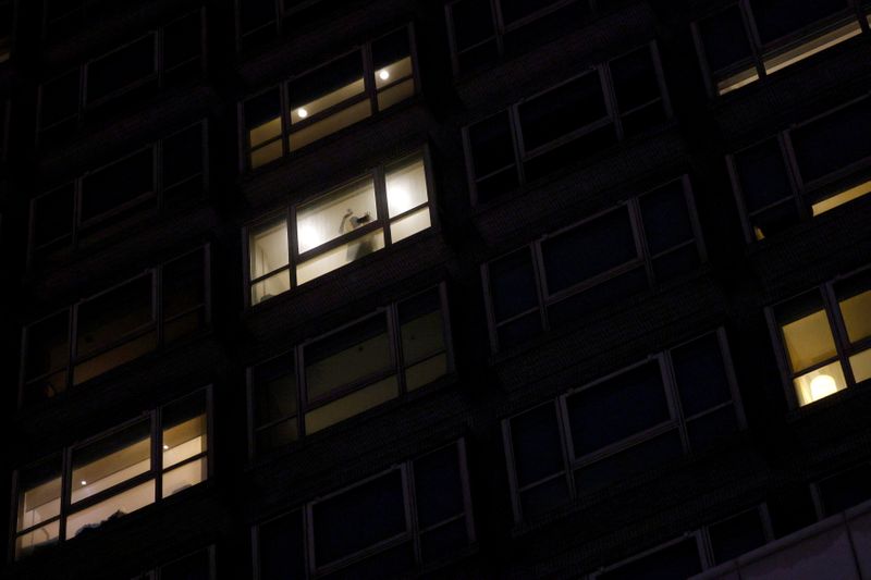 A woman waves to her friend while staying inside a quarantine hotel, during the coronavirus disease pandemic, in Hong Kong on Aug. 30.