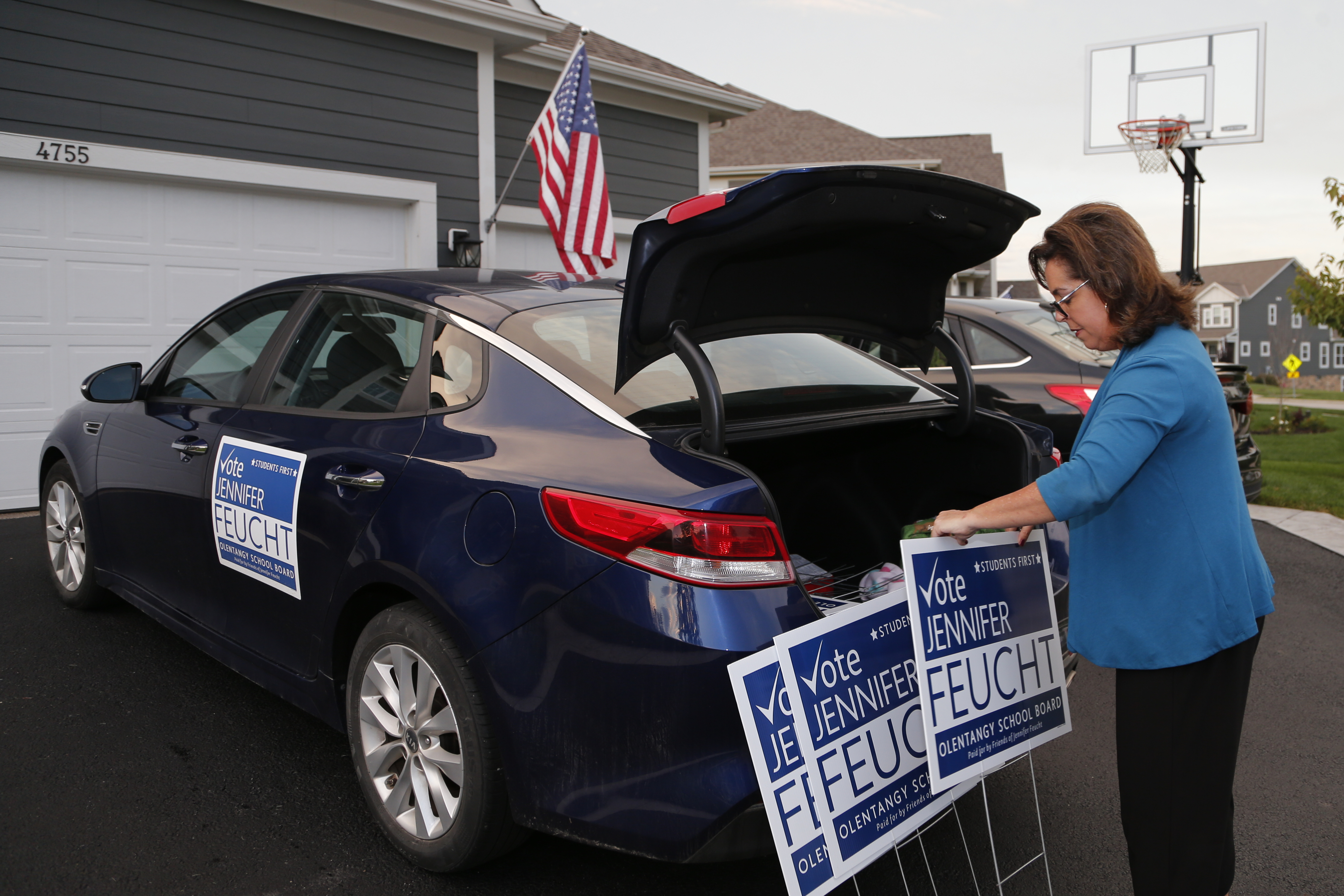 Jennifer Feucht, candidate for Olentangy Local Board of Education, delivers campaign flyers and yard signs to Brad and Tina Krider Thursday, in Westerville, Ohio.