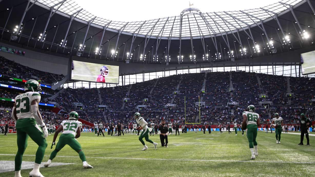 New York Jets players warm-up before an NFL football game between the New York Jets and the Atlanta Falcons at the Tottenham Hotspur stadium in London, England, Sunday, Oct. 10, 2021.