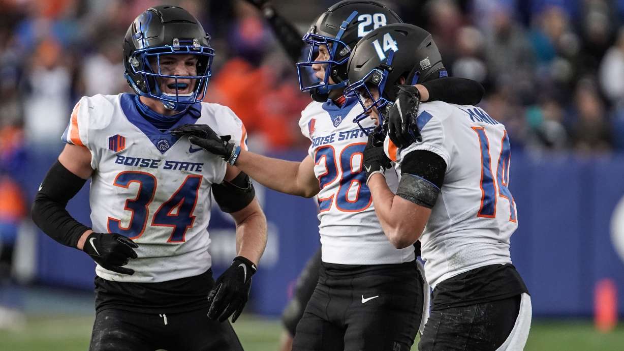 Boise State players celebrate a turnover as they compete against BYU during an NCAA college football game at LaVell Edwards Stadium in Provo on Saturday, Oct. 9, 2021.