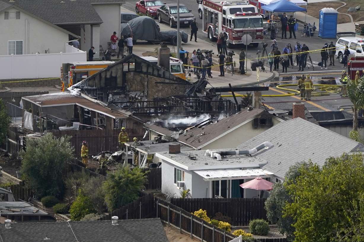 Emergency crews work a the scene of a small plane crash, Monday, in Santee, Calif. Authorities say at least two people were killed and two others were injured when the plane crashed into a suburban Southern California neighborhood, setting two homes ablaze.