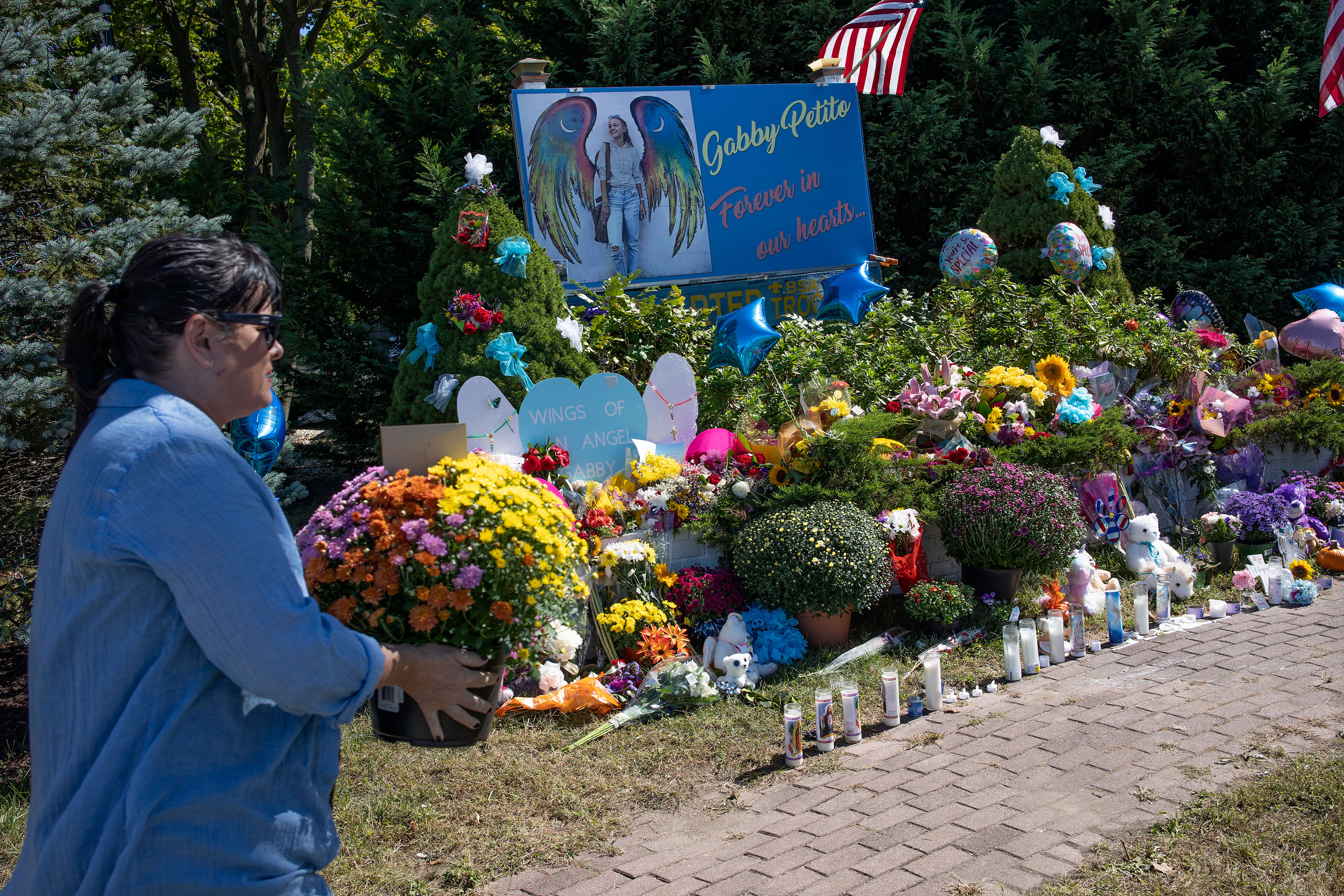 Members of the public leave flowers at a memorial site for Gabby Petito on Sept. 26 in Blue Point, Long Island, New York. Gabby Petito's cause of death was ruled to be strangulation and the manner of death was homicide, Teton County Coroner Dr. Brent Blue said on Tuesday.