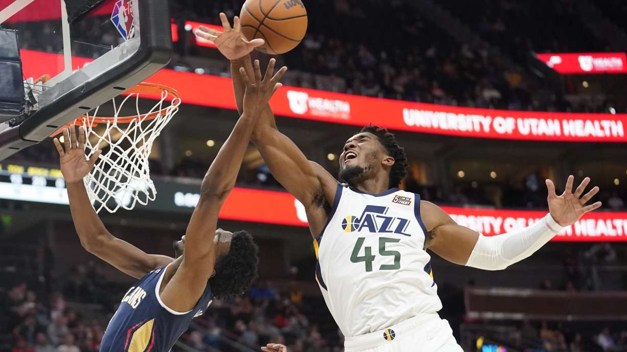 Utah Jazz guard Donovan Mitchell (45) blocks a shot by New Orleans Pelicans forward Herbert Jones, left, in the first half of a preseason NBA basketball game Monday, Oct. 11, 2021, in Salt Lake City.