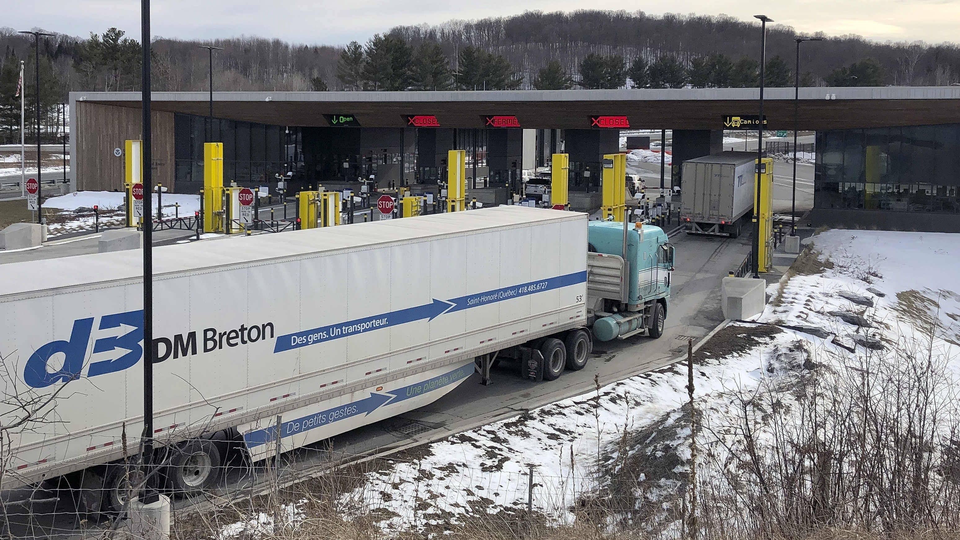 Truck traffic from Canada waits to cross the border into the United States in Derby Line V ton Wednesday, March 18, 2020. The U.S. will reopen its land borders to nonessential travel next month, ending a 19-month freeze due to the COVID-19 pandemic as the country moves to require all international visitors to be vaccinated against the coronavirus.