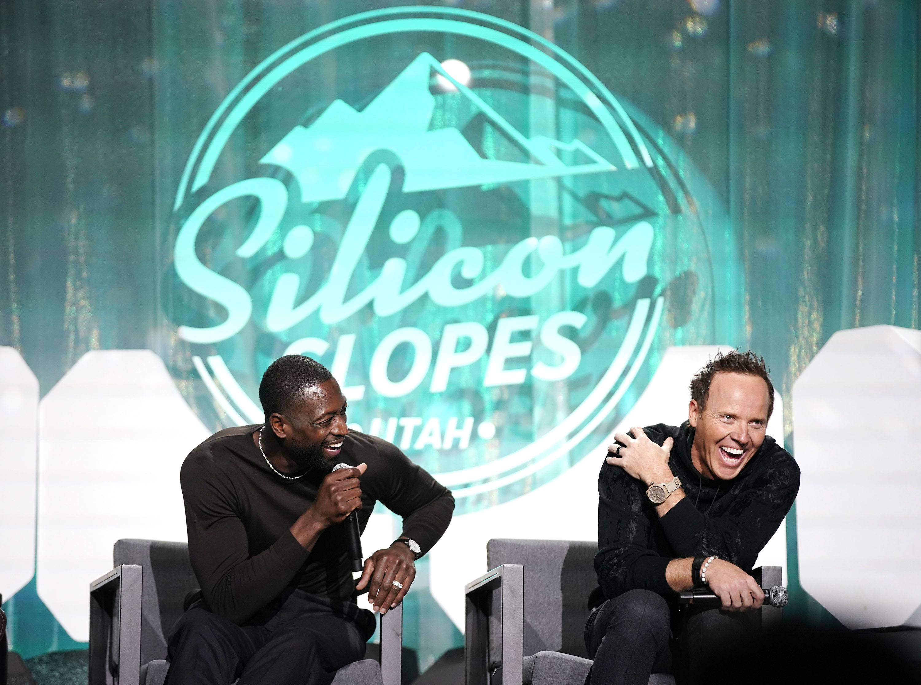 Dwyane Wade, part owner of the Utah Jazz, left, and Jazz owner Ryan Smith laugh as they talk about rebranding effort for the team at the Silicon Slopes Summit at the Salt Palace in Salt Lake City on Wednesday, Oct. 13, 2021.