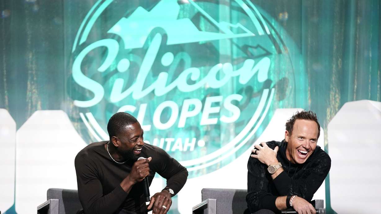 Dwyane Wade, part owner of the Utah Jazz, left, and Jazz owner Ryan Smith laugh as they talk about rebranding effort for the team at the Silicon Slopes Summit at the Salt Palace in Salt Lake City on Wednesday, Oct. 13, 2021.