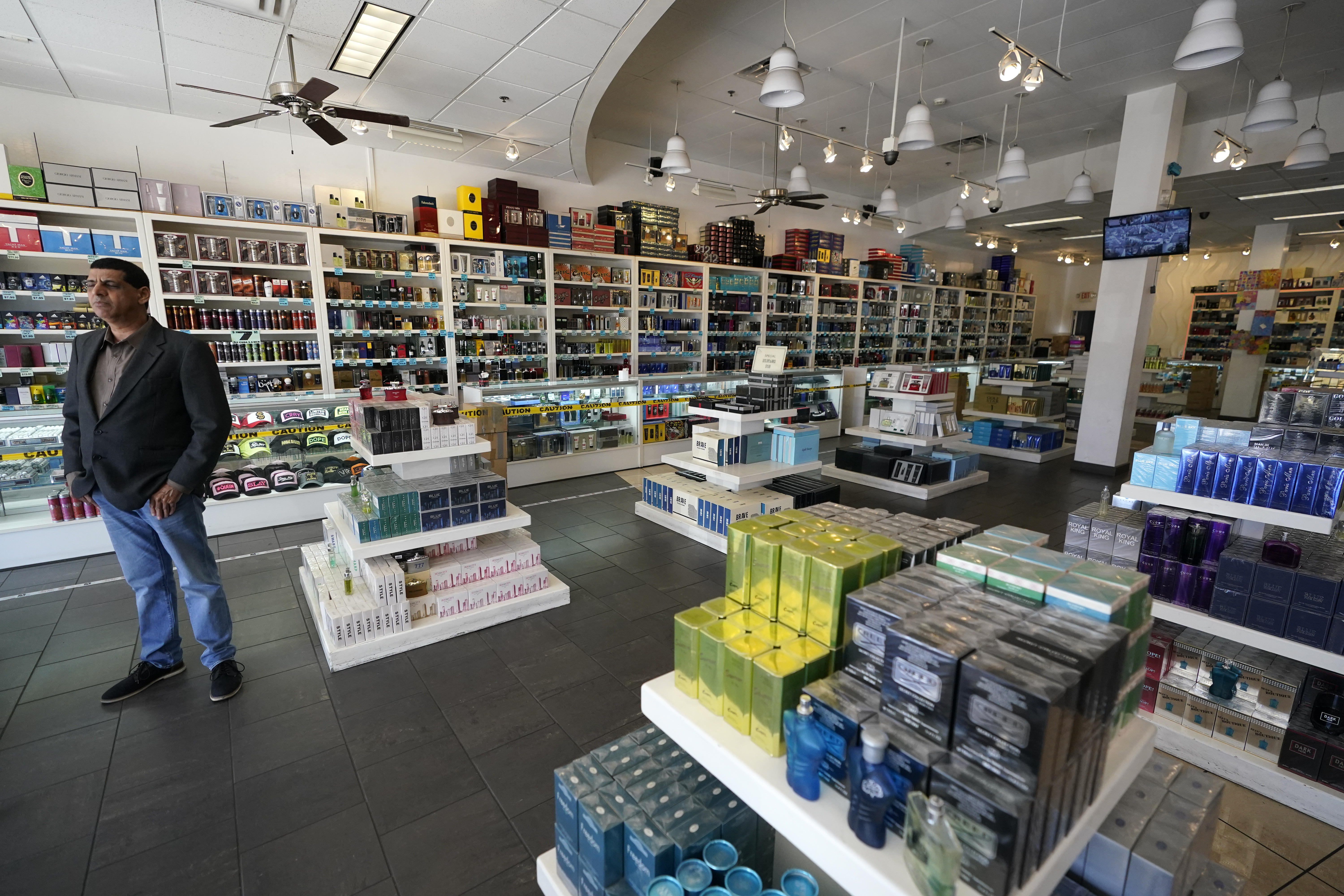 Satish Sharma, owner of Perfume Network of California, stands in his store near the border with Tijuana, Mexico, on Wednesday, Oct. 13, 2021, in San Diego. Beleaguered business owners and families separated by COVID-19 restrictions rejoiced Wednesday after the U.S. said it will reopen its land borders to nonessential travel next month, ending a 19-month freeze.