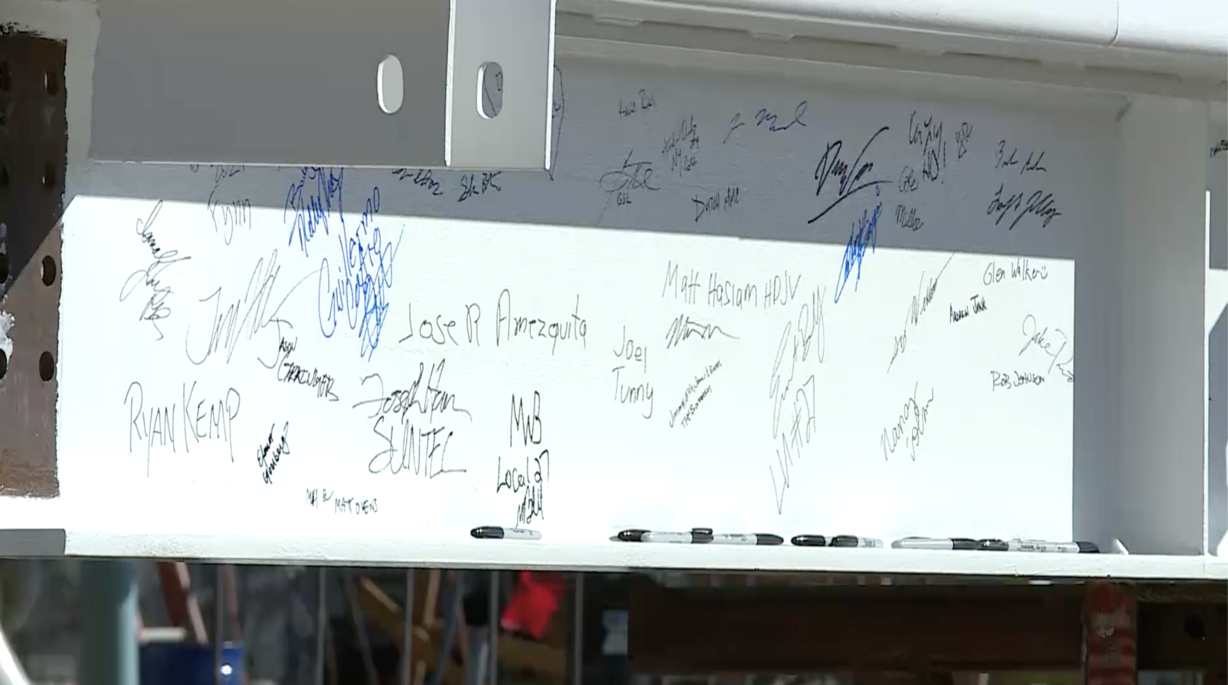 Workers added their signatures to a huge steel beam before it was hoisted to the top of the future concourse A at the Salt Lake City International Airport on Wednesday, Oct. 13, 2021.