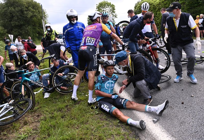 Rider Cyril Lemoine of France receives medical attention, June 26. A French woman is on trial after she sent one cyclist tumbling — with dozens more falling to the ground as a consequence — because of a cardboard sign she was holding at a television camera, facing away from the cyclists. 