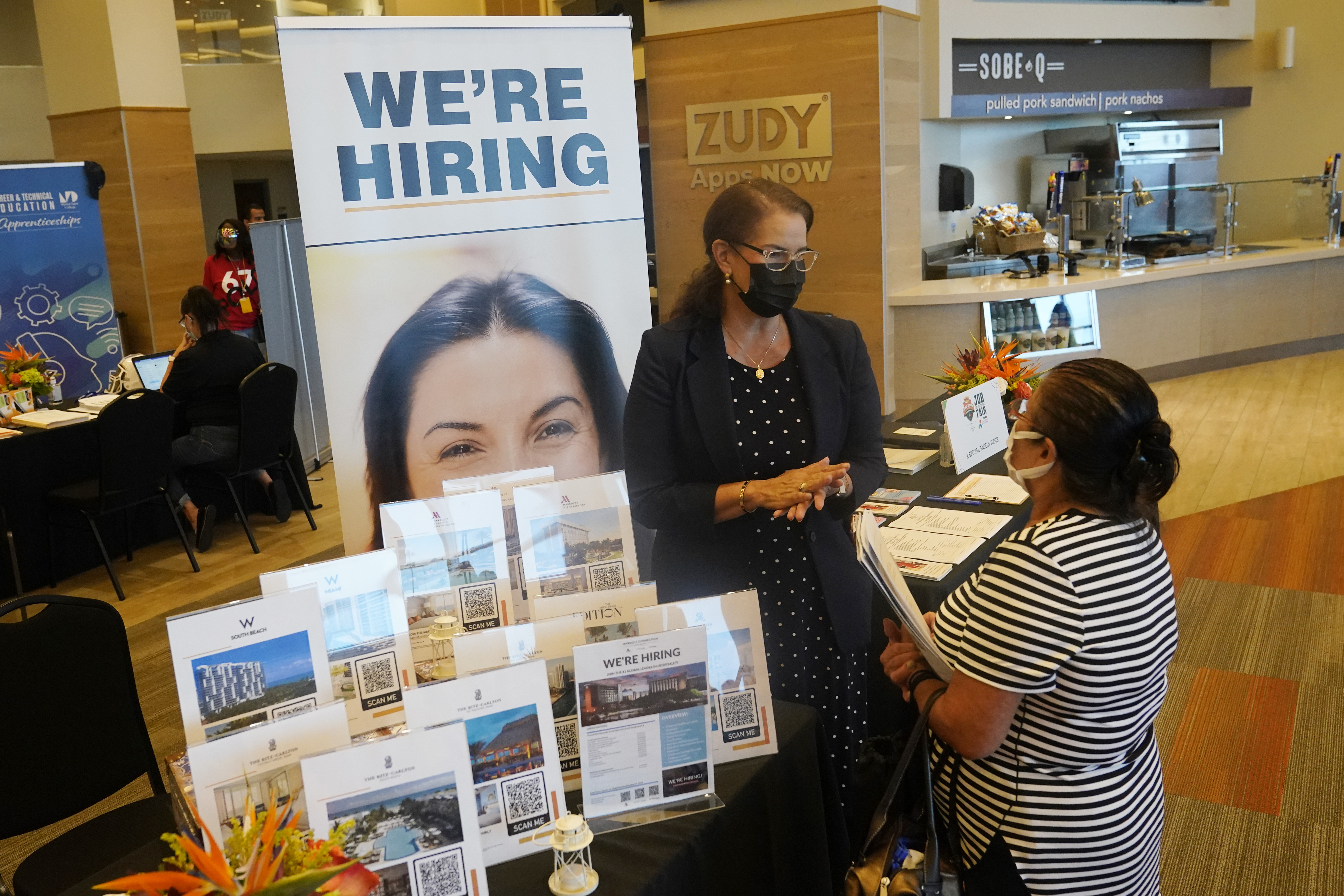 Marriott human resources recruiter Mariela Cuevas, left, talks to Lisbet Oliveros, during a job fair at Hard Rock Stadium, Sept. 3, in Miami Gardens, Fla.  The number of Americans seeking unemployment benefits moved up last week to 332,000 from a pandemic low, a sign that worsening COVID-19 infections may have slightly increased layoffs.