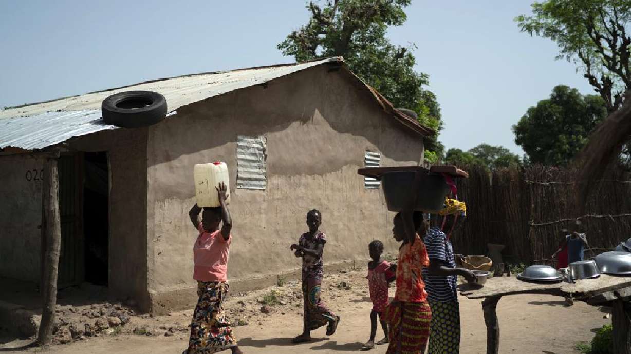 Lama Mballow carries a gallon of water collected from a local well at the Sare Gibel village in Bansang, Gambia, Wednesday, Sept. 29, 2021. Mballow, who has a 4-year-old son and another child on the way, has no plans to get vaccinated after giving birth. The persistent rumor that COVID-19 vaccines affect fertility has been especially troublesome in predominantly Muslim countries like Gambia and Somalia were polygamy is common.