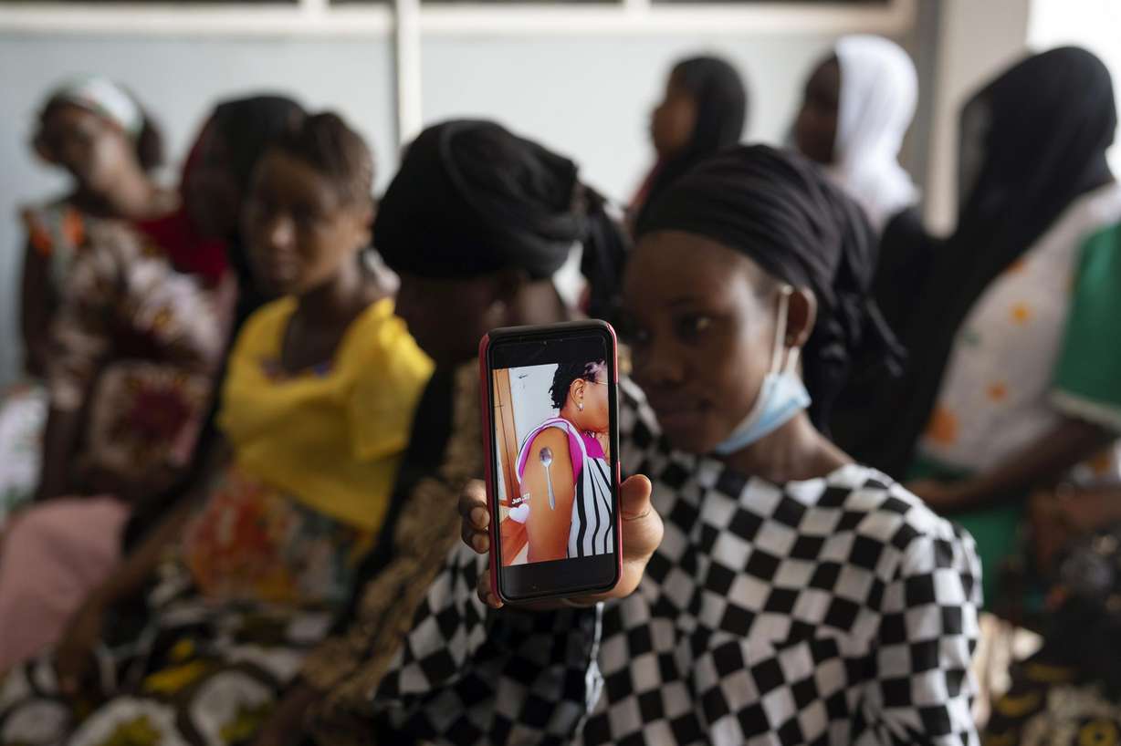 Oumie Nyassi shows a video circulating on the internet and that has been confirmed as fake news of a woman claiming she was magnetized after receiving the COVID-19 vaccine, in a doctors office at Serrekunda, Gambia hospital, Thursday Sept. 23, 2021.