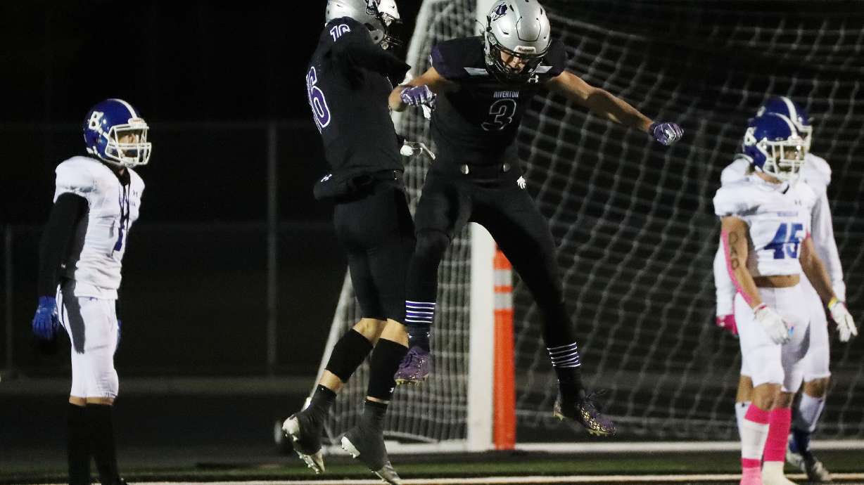 Riverton’s Garrett Sohm (16) and Josh Jacobson (3) celebrate a touchdown against Bingham in Riverton on Thursday, Oct. 14, 2021.