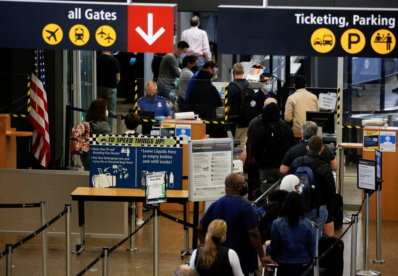 Travelers queue in a security line limited to every other lane for social distancing at Seattle-Tacoma International Airport in SeaTac, Washington, April 12.