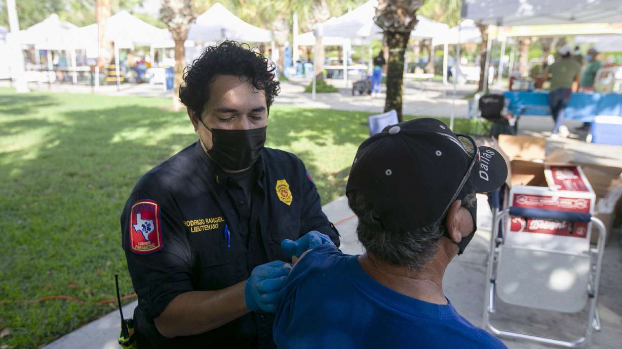 Brownsville Fire Lt. Rodrigo Rangel places a bandage over Homero Ortega's vaccine injection spot at a pop-up COVID-19 vaccine clinic, on Aug. 28, 2021, in Brownsville, Texas. A new study says there was "zero difference" in vaccination rates in states that held lotteries compared to those that didn't.