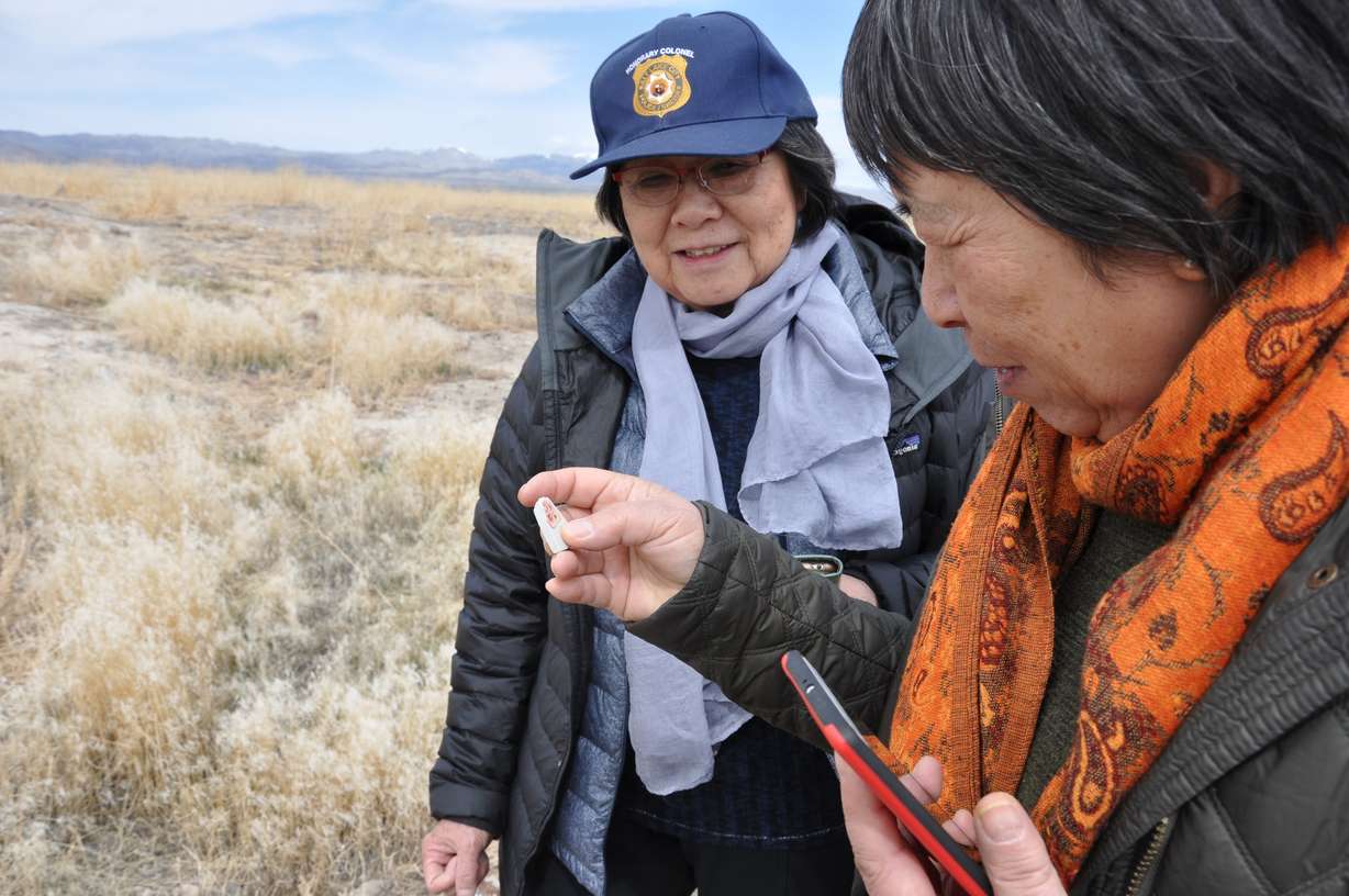 Margaret Yee, chairwoman of the Chinese Railroad Worker Descendants Association, and volunteer excavator Siu Lin Santee examine an artifact related to the Chinese residents of Terrace, Utah.