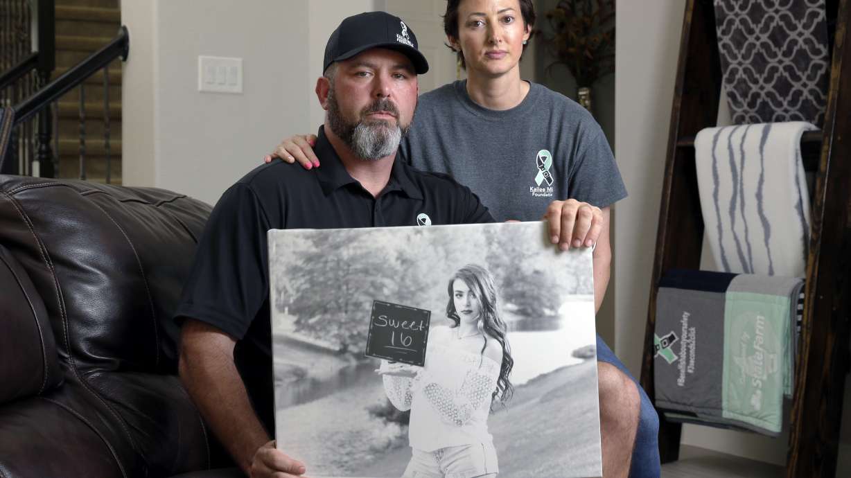 In this Oct. 12 photo, David and Wendy Mills, parents of Kailee Mills who was killed four years ago in an automobile accident when riding in the back seat without a seat belt, with a photo of their daughter at their home in Spring, Texas. The teenager was riding to a Halloween party in 2017 just a mile from her house when she unfastened her seat belt to slide next to her friend and take a selfie. Moments later, the driver veered off the road and the car flipped, ejecting her.