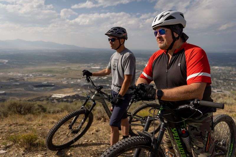 David Dobbins, Draper city manager, and Mayor Troy
Walker pose for a photograph on a trail overlooking the city in
Draper’s Corner Canyon trail network on Wednesday, Aug. 25, 2021.
In the background at left is the Utah State Prison, which will be
replaced with The Point development once it relocates to a new site
near the airport.