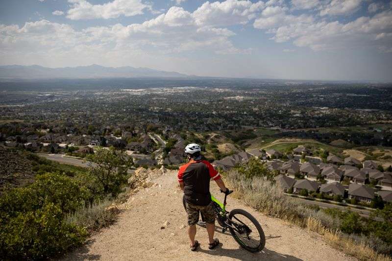 Draper Mayor Troy Walker looks over part of the town
while taking journalists on a mountain biking tour of the city’s
Corner Canyon trail network on Wednesday, Aug. 25,
2021.
