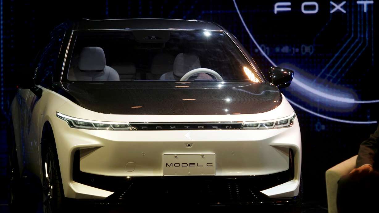 A Foxtron Model C electric vehicle is seen unveiled at a Foxconn event in Taipei, Taiwan on Monday. With electric car sales soaring and regulations increasingly favoring zero-emission vehicles, a flurry of announcements on Monday showed how the global auto industry has kicked into a higher gear as it races to speed past the fossil-fuel car era.
