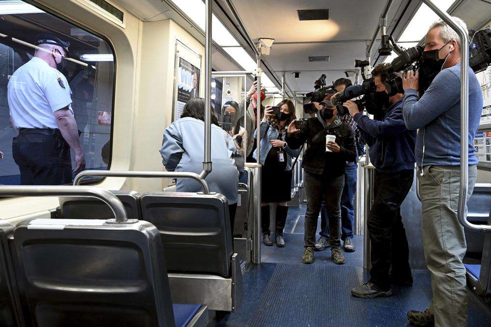 SEPTA Transit Police Chief Thomas Nestel III, seen through window at left, stands by following a news conference on an El platform at the 69th Street Transportation Center, Monday, Oct. 18, 2021, in Philadelphia, following a brutal rape on the El over the weekend. SEPTA subway elevated Chief Officer Chrystalle Hooper, center, demonstrates the emergency call boxes on SEPTA trains and how to properly contact police from their cars.
