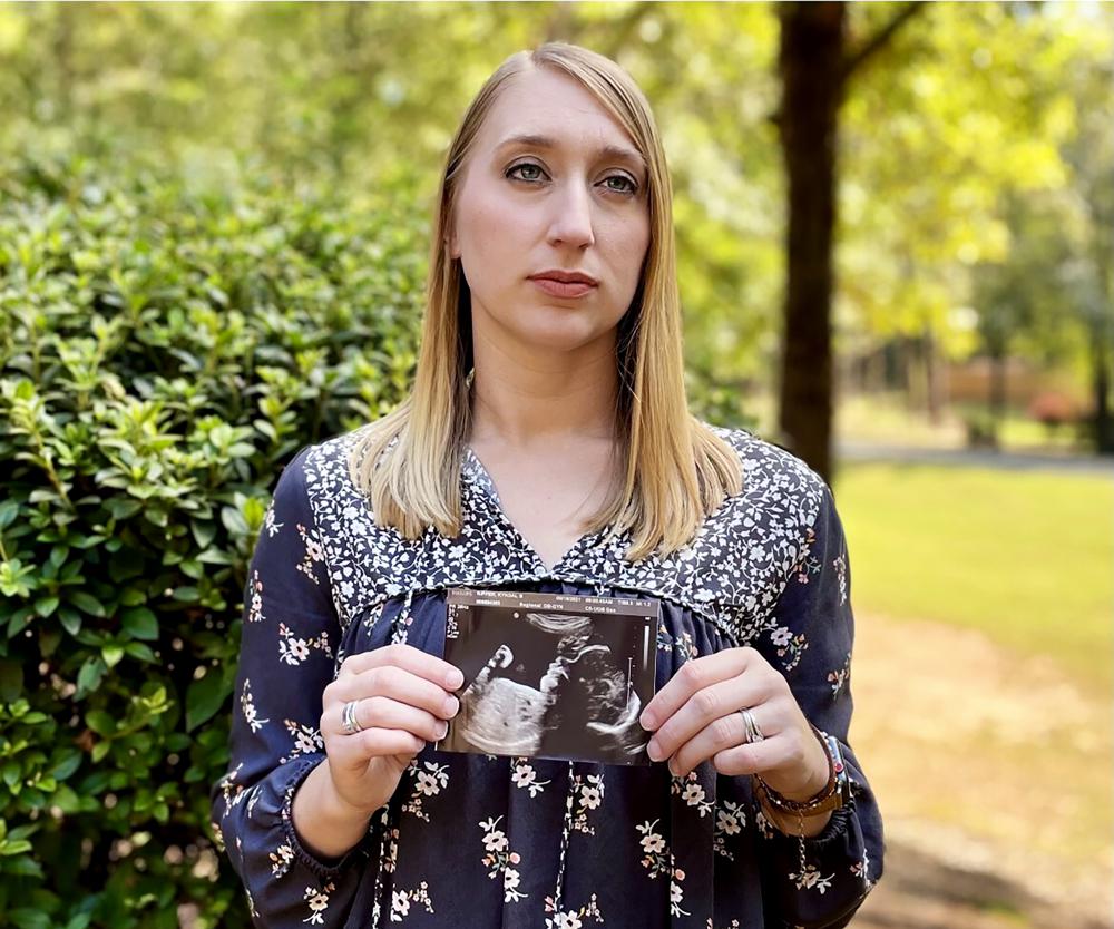 Kyndal Nipper, of Midland, Ga., who suffered a stillbirth after becoming ill with COVID-19 in her third trimester, holds an ultrasound image of the son she lost while standing outside her home on Friday. Nipper, who was unvaccinated, is encouraging women to get vaccinated.