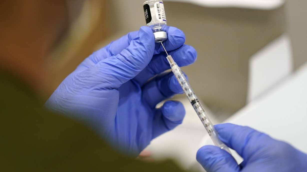 A health care worker fills a syringe with the Pfizer COVID-19 vaccine at Jackson Memorial Hospital in Miami on Oct. 5. The government is close to publishing the details of a new vaccination-or-testing rule covering more than 80 million Americans at companies with 100 or more workers.