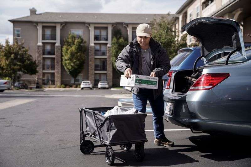 Azim Kakaie takes out groceries from his friend’s car
at his home in Salt Lake City on Oct. 13. Kakaie,
who worked as an air traffic controller at the Hamid Karzai
International Airport in Kabul, fled Afghanistan following the
Taliban takeover and arrived in Utah on Sept. 1.