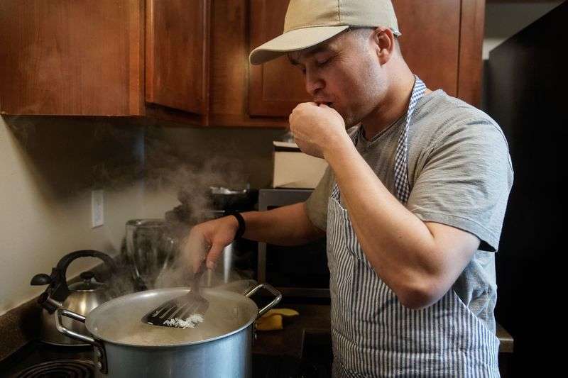 Azim Kakaie checks on the rice as he prepares for lunch
at his home in Salt Lake City on Oct. 13.