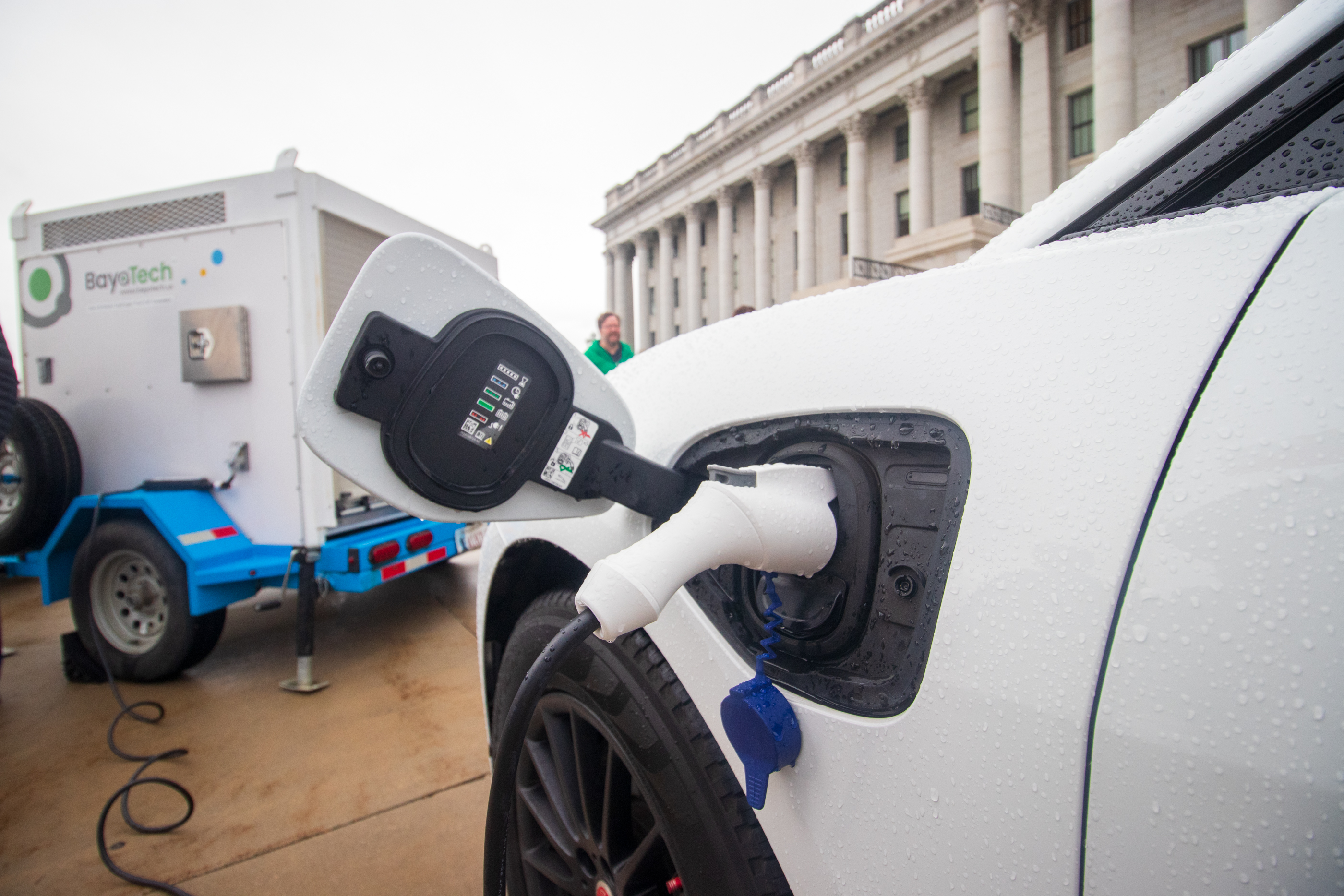 An electric vehicle is charged by a hydrogen power generator during an event outside of the Utah Capitol Tuesday.