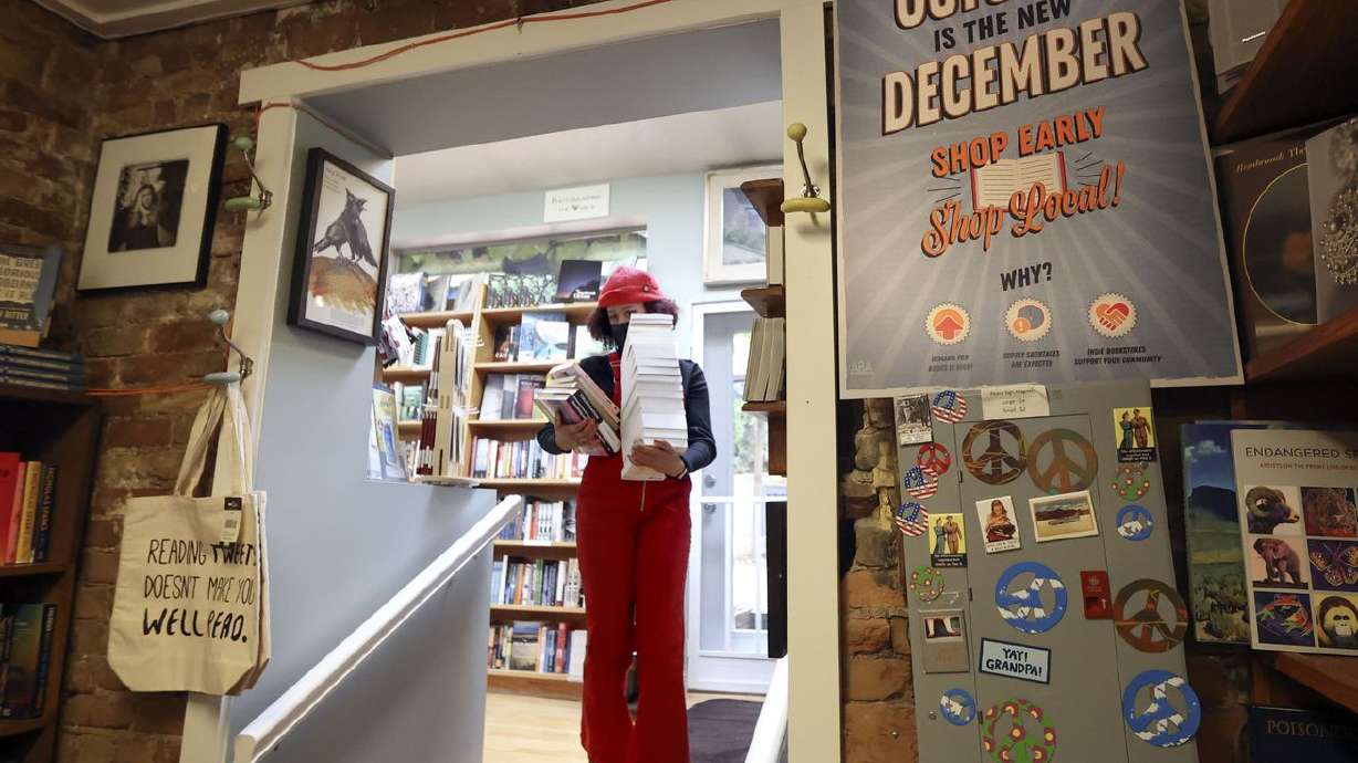 Alexis Powell carries a stack of books to the register at The King’s English Bookshop in Salt Lake City on Tuesday.