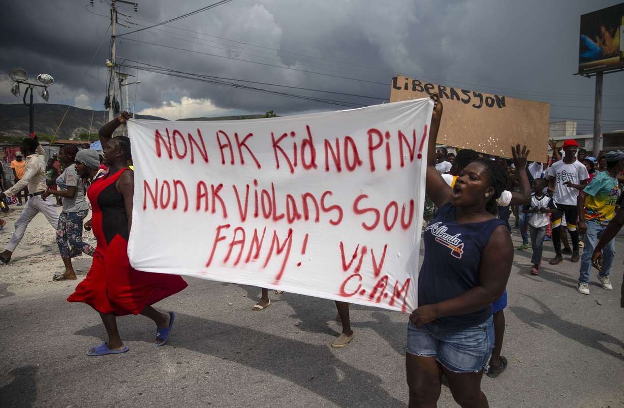 People protest carrying a banner with a message that reads in Creole: "No to kidnappings, no to violence against women! Long live Christian Aid Ministries," demanding the release of kidnapped missionaries, in Titanyen, north of Port-au-Prince, Haiti, Tuesday.