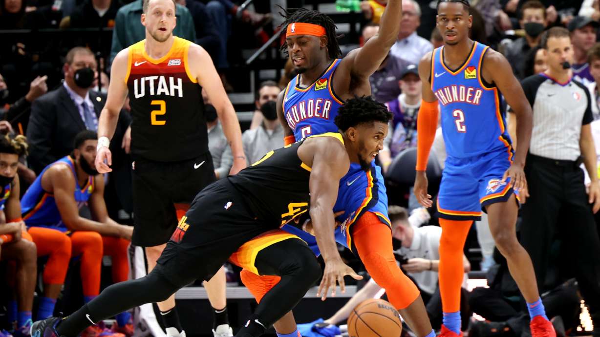 Utah Jazz guard Donovan Mitchell (45) drives on Oklahoma City Thunder forward Luguentz Dort (5) as the Utah Jazz and the Oklahoma City Thunder open the 2021-22 season at Vivint Arena in Salt Lake City on Wednesday.