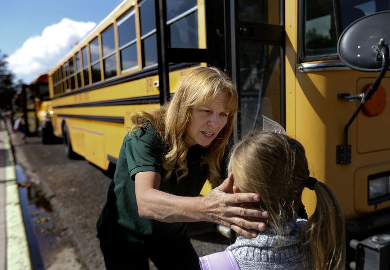 Bus driver Dawn Bittner looks at an injury on an
elementary school student’s forehead at Monroe Elementary School in
Monroe, Sevier County, on Sept. 29.