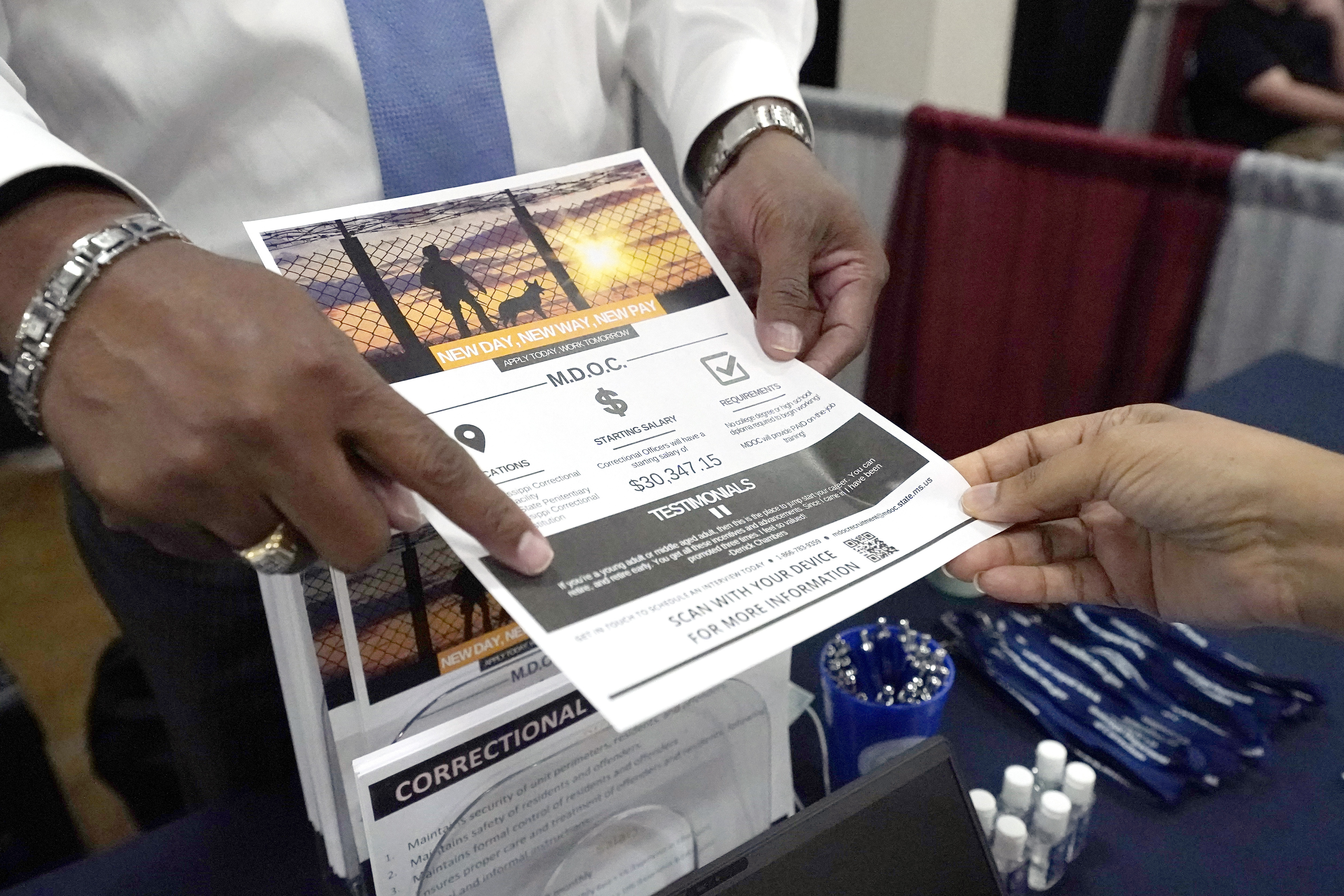 Curtis McCray, a Mississippi Department of Corrections recruiter, left, points out a positive testimonial to a job applicant during the Lee County Area Job Fair in Tupelo, Miss., Oct. 12.