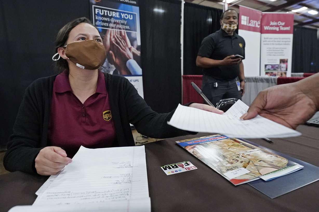 Ariel Jones, a United Parcel Service human resources intern, hands an applicant an information sheet, while the human resources specialist for the company, Mareno Moore, right, monitors the interaction during the Lee County Area Job Fair in Tupelo, Miss., Oct. 12.
