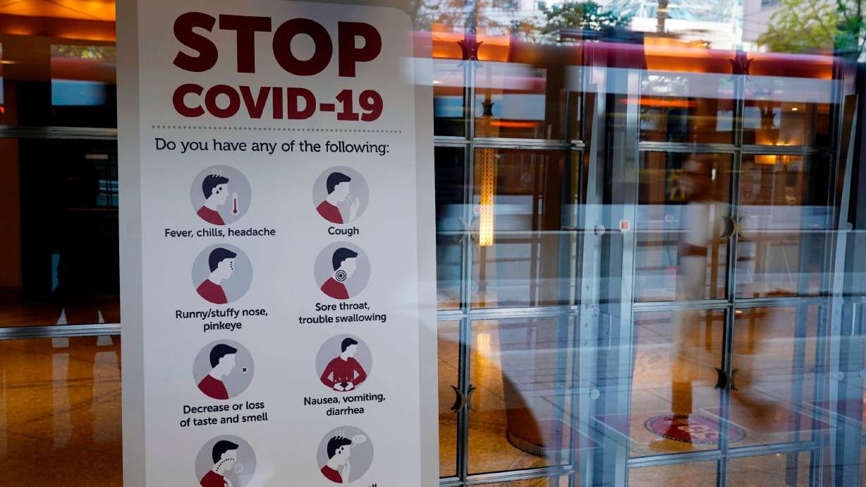 A sign reminds festivalgoers to monitor themselves for possible coronavirus symptoms in the entrance of the Princess of Wales Theatre on day one of the 2021 Toronto International Film Festival, on Sept. 9, in Toronto
