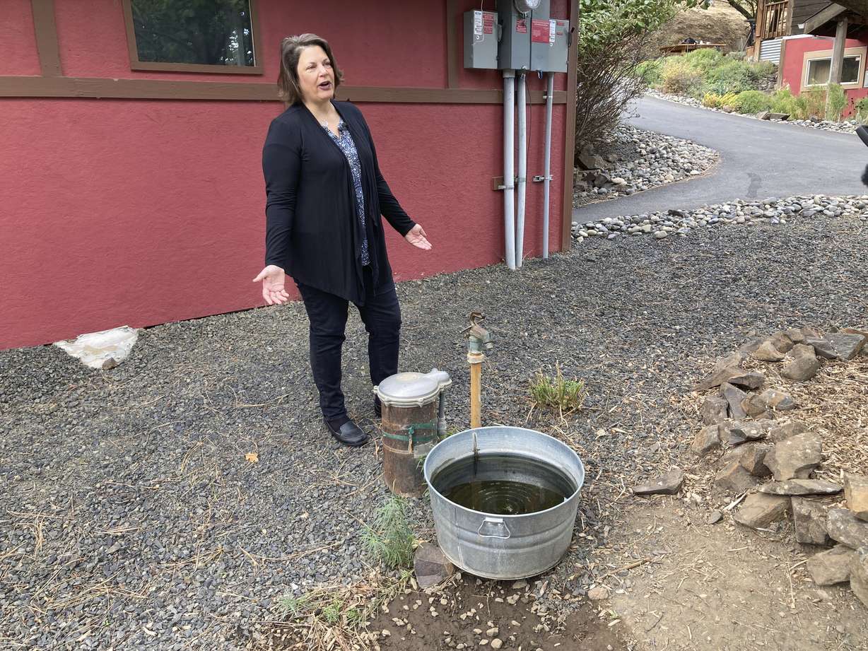 Dawn Rasmussen stands at her well at her property on the outskirts of The Dalles, Oregon, on Oct. 5. She says the water table that her well draws from has dropped 15 feet in the last 15 years.