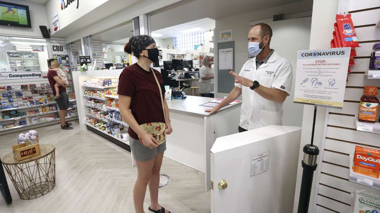 Bailey Stanger, left, talks to pharmacist Trevor Jolley after getting the Johnson & Johnson COVID-19 vaccine at Jolley’s Compounding Pharmacy in Salt Lake City on May 27. Utah health officials confirmed 1,614 new COVID-19 cases and 10 deaths on Tuesday.