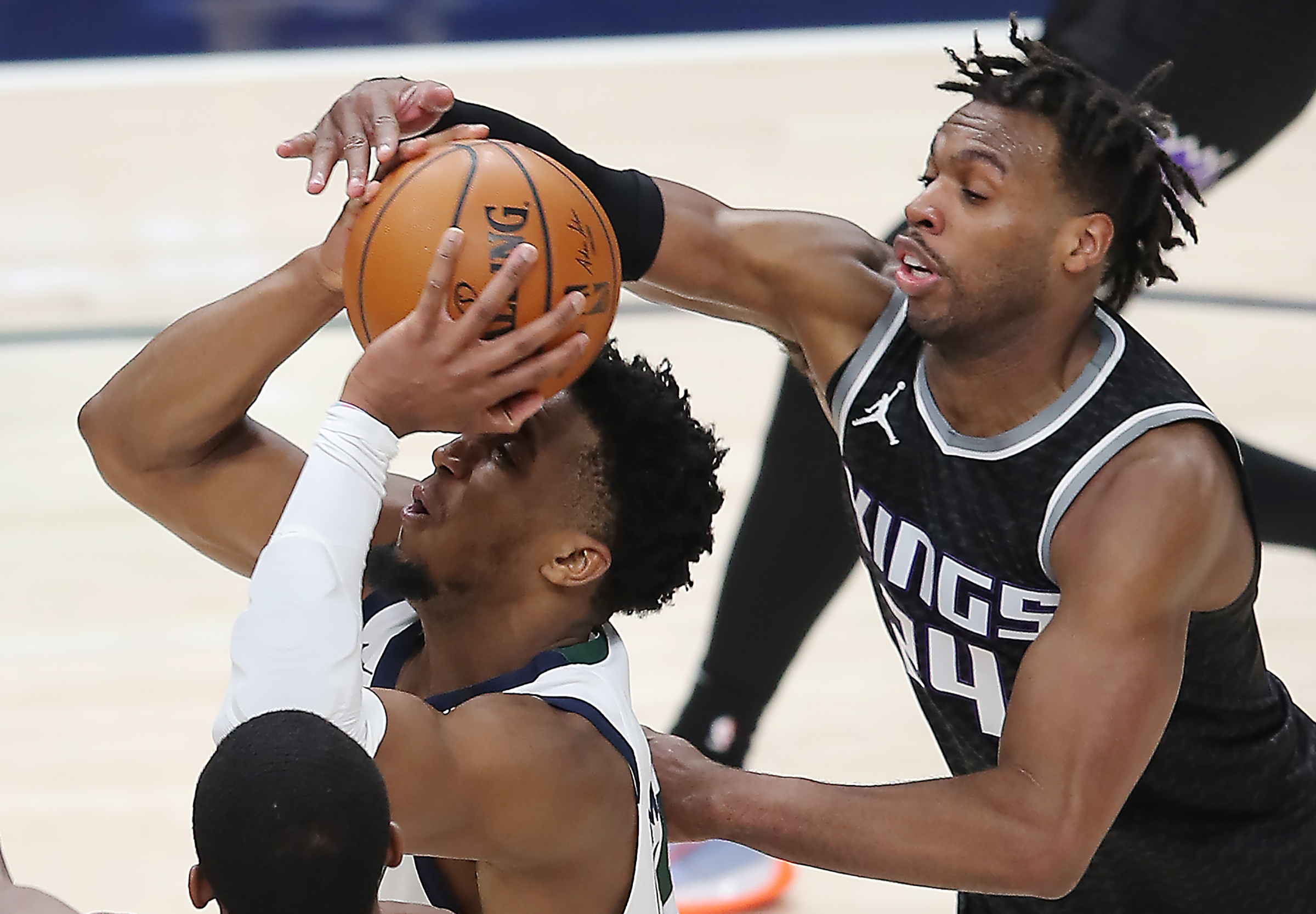 Utah Jazz guard Donovan Mitchell (45) powers up a shot with Sacramento Kings guard Buddy Hield (24) defending as the Utah Jazz and the Sacramento Kings play an NBA basketball game at Vivint Arena in Salt Lake City on Saturday, April 10, 2021.